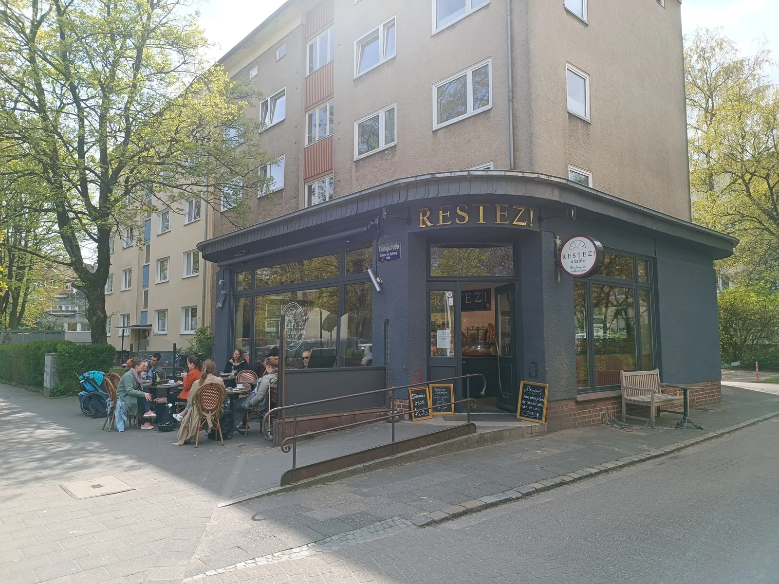 Restez! à table an der Ecke Koldingstraße mit Gästen an den Außentischen